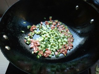 7、创意菠萝饭,先将火腿丁和黄瓜丁略翻炒两下。