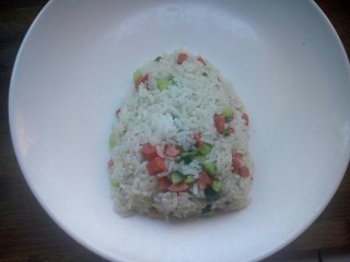 9、创意菠萝饭,翻炒片刻后盛入盘中,将米饭整形为上小下大的形状。