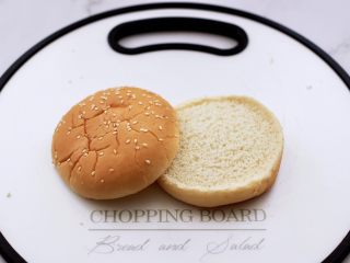 4、午餐肉黄瓜汉堡包,把汉堡包胚切成两半。