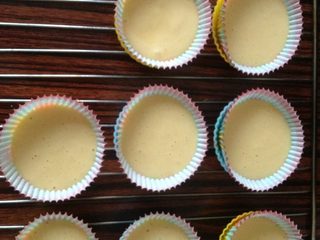 5、纸杯奶油蛋糕,如图均匀倒入纸模中8分满，烤箱预热180度上下火烤20分钟，取出放凉。