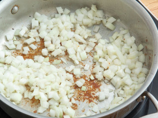 2、炖羊肉土豆泥派,锅留底油，加入洋葱，胡萝卜翻炒至洋葱变成金黄色，加入孜然、白葡萄酒