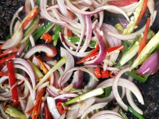 12、香辣下饭菜～客家小炒鱼干,锅中再放一点油，放葱，辣椒干，小米辣煸炒，再倒入洋葱和青椒(红椒)丝翻炒。