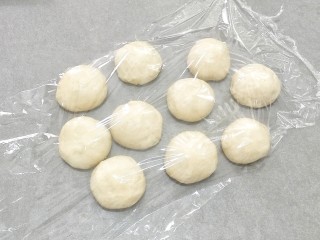 4、椰蓉奶油面包,把面团平均分成十份多元盖上保鲜膜松弛15分钟。，28×28的烤盘可以做两盘