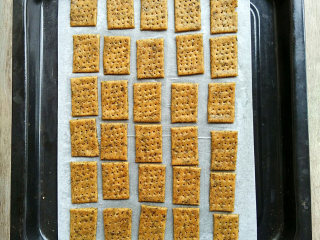 7、海苔全麦苏打饼,用刀分割成小块，用刀叉在表面戳些小洞，然后面饼摊开分布油纸上，放上烤盘。