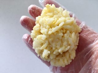 4、肉松小鸡饭团—带给宝宝更多有趣的童年回忆,把剩余1/3饭团盖在上面，边缘粘合，用手搓成椭圆鸡蛋型。