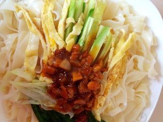 6、炸酱面,准备配菜。鸡蛋打散，煎成鸡蛋饼，切丝。黄瓜切丝。大头菜、油麦菜入锅焯水。