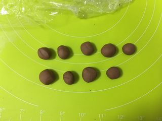 6、呆萌熊猫豆沙包,把可可面团分为9小份，其中3份做熊猫的耳朵，6份做眼袋和鼻子