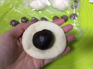 7、呆萌熊猫豆沙包,豆沙分为20g一份，滚圆，包入原色面团中，白面团要揪一点点下来作为熊猫的眼睛珠