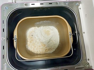 2、#宝宝零食#自创奶酪夹心燕麦棒,牛奶倒入面包机，再将燕麦，面粉撒在上面，在面粉里挖个小洞，把酵母埋在面粉里，启动和面功能，和面10分钟即可