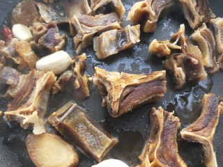 16、腊板鸭焖杏鲍菇萝卜,看腊板鸭皮有卷起变色后，加两勺料酒。