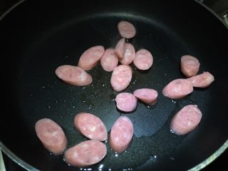 6、双菇炒热狗,锅中倒入油,放入热狗,先用中小火煎一面金黄