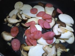 11、双菇炒热狗,倒入没有完全变熟的热狗,盖上锅盖煮一会