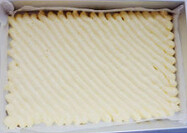 5、草莓卷,将拌匀的面糊装入裱花袋，在烤盘上挤出斜条状