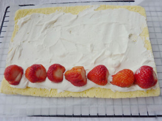 7、草莓卷,取70g奶油加入10g糖打发，把奶油涂抹在晾凉的蛋糕片上,排上草莓