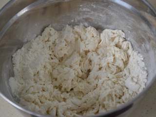 3、家常油饼,边加边用筷子慢慢搅拌，搅拌成这样的小面絮状。