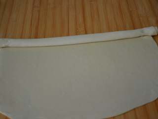 6、家常油饼,从一侧这样慢慢卷起来。