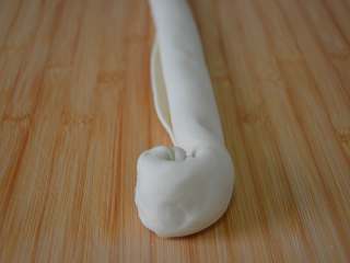 8、家常油饼,卷好后再从一侧开始这样卷。