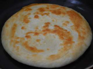 12、家常油饼,另一面也成型后，翻一下面继续煎。