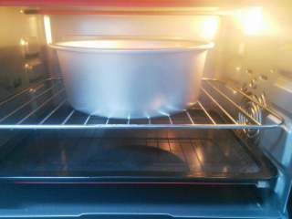 6、酸奶蛋糕,烤盘注入清水放烤箱最底层,烤箱预热,150度上下火,将蛋糕放烤架上,放入烤箱倒数第二层,烘烤一小时即可。