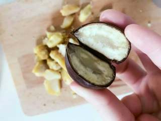 1、宝宝辅食：苹果栗子饼,取出煮好的栗子，放入凉白开中冷却，然后用刀切开取出栗子肉。