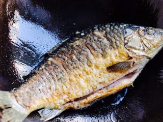 5、鲫鱼萝卜奶白汤,待一面煎好后，把鲫鱼翻过来煎另一面，直至鲫鱼两面煎到金黄色。