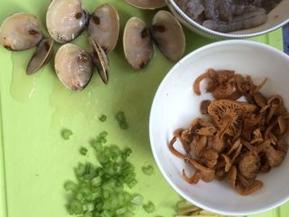 2、文蛤虾仁海鲜粥,将文蛤对半切开（我的文蛤是放冰箱冷冻的所以需要切开，如果是新鲜的文蛤可忽略这一步），芹菜切小丁，姜切丝，鸡针菇泡开，备用。