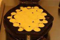 4、鸡蛋仔,挤入面糊，面糊的份量可以参考下图，就是刚刚好一半模子满。停留几秒钟，盖上鸡蛋仔的另一半盖子，马上翻面。只要马上翻面，面糊才不会流的到处都是，而是落入模子的另一面里；