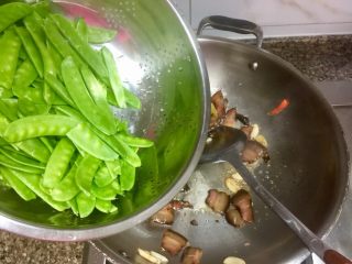 15、小清新&烟火气➕荷兰豆清炒酱油肉,转中大火，加入荷兰豆，翻炒两三分钟左右，其中可以分几次淋一点清水，保证荷兰豆熟透