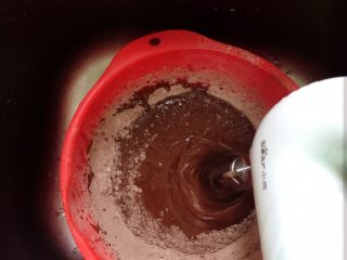 4、可可樱桃慕斯蛋糕,分三次逐步筛入低筋粉和可可粉。搅拌。