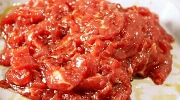 4、葱爆牛肉,将腌好的牛肉中加入适量清水，抓匀，在加入一勺淀粉抓匀，这样炒出来的牛肉更滑嫩。