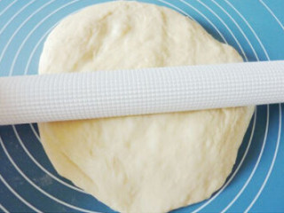 4、肉松面包卷,擀成与烤盘差不多大小的面片，放入烤盘内