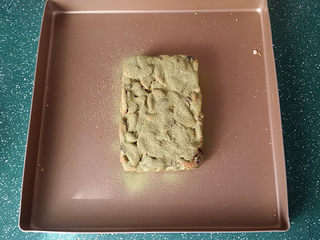 12、抹茶雪花酥,取适量备好的抹茶奶粉用筛网筛在上面