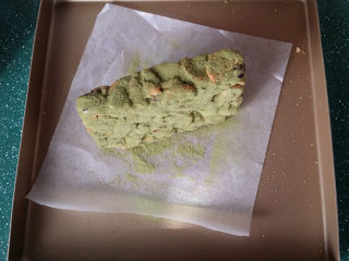 13、抹茶雪花酥,然后拿起来将糖块、将其它几面也都筛上抹茶奶粉