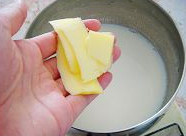 2、面包布丁,牛奶加糖放小锅内，放火上加热至糖融化。