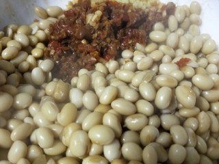 10、佐粥下饭的黄豆辣椒酱,趁热倒入辣椒酱和姜末的大碗中。