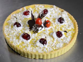 13、布丁水果派,将冻好的布丁派用鲜奶油、巧克力件、樱桃、圣女果、白巧克力碎装饰好即可。