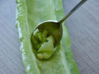 2、凉拌苦瓜,切开,去籽,用勺子把白瓤都给刮干净,可以去除一部分苦味。