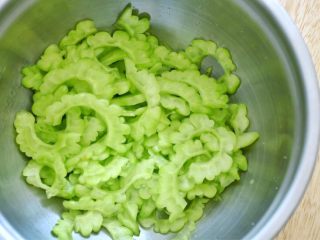 4、凉拌苦瓜,放点盐,抓匀,静置15分钟,让苦瓜出水,把水倒掉,这一步也是为了去除苦味。