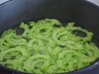 5、凉拌苦瓜,盐渍好的苦瓜用水冲洗,锅里水烧开,苦瓜放进去煮沸。喜欢口感脆的煮沸就好,喜欢口感软一点的可以多煮几分钟。