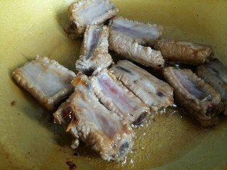 7、可以让你吮指的糖醋排骨,开中火，倒入排骨快速翻炒裹上糖色。大概翻炒1分钟。