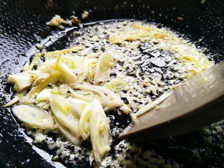 12、美味香炒螃蟹,锅内剩少许底油,把切好的葱姜蒜一起倒入煸炒。