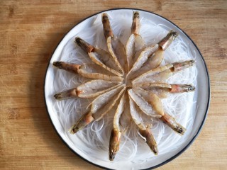 5、蒜蓉粉丝开背虾,将开好背的虾均匀在粉丝上铺开。