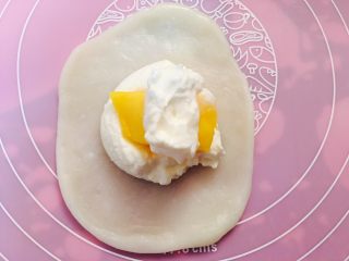 5、芒果大福,手上抹些手粉，取一小团面团擀平，放入适量淡奶油、水果，像包子一样收口