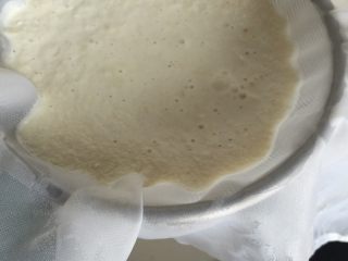7、豆腐,准备锅，漏勺上铺过滤纱布，把豆浆分次过滤。