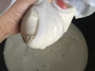 8、豆腐,纱布包裹豆渣用手挤干，不要浪费。只有多挤出豆浆来，等下的豆腐才有机会做成功哦！