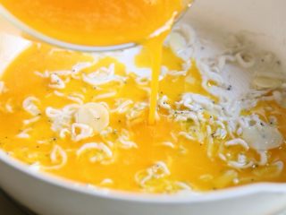 10、银鱼炒蛋,用锅铲把银鱼铺开，小心倒入蛋液。