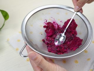 3、手工面,用勺子按压碎，将火龙果汁按压出来（也可以用榨汁机，但是榨汁机炸出来的有黑点）