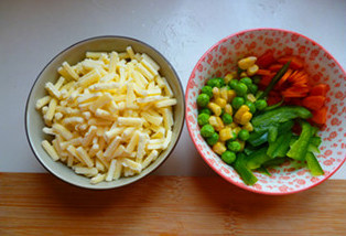 6、萨拉米香肠PIZZA,松弛时准备馅料，胡萝卜切成小碎粒，青椒切细丝，速冻玉米青豆回温并沥干水分备用，萨拉米香肠回温备用。