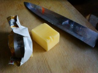 4、夹心水果派-健康蒸蛋糕,切下一小块黄油，用锅小火加热化开，盛入一个小碗中备用。黄油的效果好，利于后面脱模并且加强奶香味，没有黄油可以用其他味道小调和油