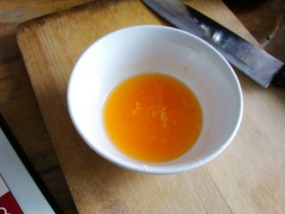 5、夹心水果派-健康蒸蛋糕,剥橘子，取一半挤出汁放在一个小碗里。有很多教程里用很少量白醋或者柠檬汁去鸡蛋的腥味，由于想让蒸出来的有些橘子味，我就直接用橘子代替了。同时，加入一半刚才化开好的黄油。